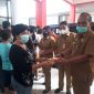 Kadis Perindustrian dan Perdagangan Kabupaten Minahasa Selatan Adrian Sumuweng menyerahkan secara simbolis minyak goreng yang dibeli oleh warga