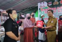 Wabup Minsel Petra Rembang memberikan bingkisan bantuan kepada warga saat menghadiri percepatan Vaksinasi Covid-19 di Tompaso Baru
