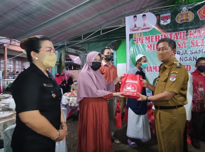 Wabup Minsel Petra Rembang memberikan bingkisan bantuan kepada warga saat menghadiri percepatan Vaksinasi Covid-19 di Tompaso Baru