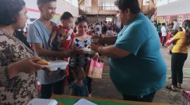 Foto: Kumtua Ferry Pangala saat memberikan makanan gratis kepada balita yang diantar oleh salah satu ayah GATI