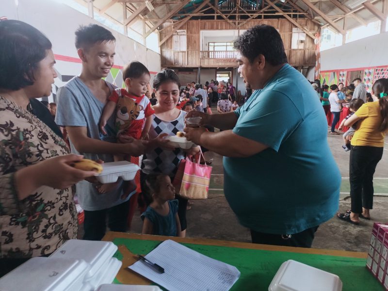 Foto: Kumtua Ferry Pangala saat memberikan makanan gratis kepada balita yang diantar oleh salah satu ayah GATI
