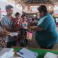 Foto: Kumtua Ferry Pangala saat memberikan makanan gratis kepada balita yang diantar oleh salah satu ayah GATI