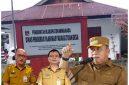 Foto: Gambar background Kantor Dinas PMD Kabupaten Minahasa; inserted photo: Bupati Minahasa, Asisten I Bidang Pemerintahan Kabupaten Minahasa, Kadis PMD Minahasa,